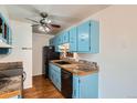 This galley kitchen features bright blue cabinets, stainless steel appliances, and hardwood flooring, offering style and function at 16259 W 10Th Ave # J5, Golden, CO 80401