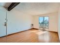A bright living room has a beamed ceiling and access to a balcony at 16259 W 10Th Ave # J5, Golden, CO 80401