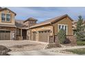 A beautiful home featuring stone and stucco accents, a tiled roof, and an attached three-car garage at 9483 Sori Ln, Highlands Ranch, CO 80126