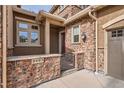 Charming front entrance with a brick wall, gate, and stone accents at 9483 at 9483 Sori Ln, Highlands Ranch, CO 80126