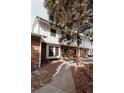 Charming townhome featuring a brick facade, white siding, and mature trees in a well-maintained community at 10330 E Jewell Ave # 67, Aurora, CO 80247