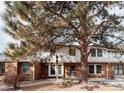 Charming townhome featuring a brick facade, white siding, and mature trees in a well-maintained community at 10330 E Jewell Ave # 67, Aurora, CO 80247