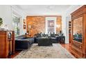 Spacious living room with exposed brick wall, hardwood floors, and a cozy atmosphere at 1141 Adams St, Denver, CO 80206