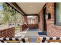 Cozy covered porch featuring brick columns, comfortable seating, and a welcoming entrance at 2568 Clermont St, Denver, CO 80207