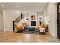 Inviting living room featuring a cozy fireplace, wood floors, and a staircase at 2568 Clermont St, Denver, CO 80207