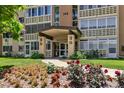 Exterior view of building entrance with covered walkway, flowers, and manicured lawn at 745 S Alton Way # 11A, Denver, CO 80247