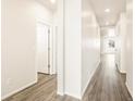 Hallway with light colored walls and wood-look floors provides ample lighting and access to rooms at 17417 E 89Th Way, Commerce City, CO 80022