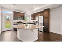 An open kitchen features dark cabinetry, stainless appliances, and granite countertops at 10071 Yampa Ct, Commerce City, CO 80022