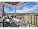 Inviting outdoor patio featuring stylish seating and scenic views of the surrounding landscape under a covered porch at 14998 Cast Pebble Cir, Parker, CO 80134