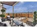 Enjoy outdoor living on this covered patio with comfortable seating and scenic views at 14998 Cast Pebble Cir, Parker, CO 80134