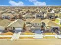 An aerial view shows the property in a neighborhood under a partly cloudy sky at 885 Hearthstone Ave, Brighton, CO 80601