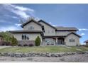 Charming home with stone accents, manicured landscaping, and a welcoming front porch exudes comfort and curb appeal at 14993 W 55Th Dr, Golden, CO 80403