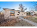 Side exterior showing a cozy single-story home with large window and carport at 1050 Uvalda St, Aurora, CO 80011