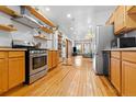 Modern kitchen with stainless steel appliances, open shelving, and hardwood flooring throughout at 3034 N High St, Denver, CO 80205