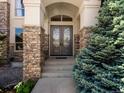 A stone-accented entryway and gorgeous, custom double doors welcome you into this home at 10057 S Shadow Hill Dr, Lone Tree, CO 80124