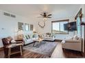 Bright living room featuring hardwood floors, comfortable seating, and a large window with scenic views at 11932 Coal Creek Heights Dr, Golden, CO 80403