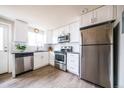 Modern kitchen with stainless steel appliances, white cabinets, and subway tile backsplash at 2714 N Federal Blvd, Denver, CO 80211