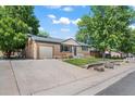 Single-story home with brick facade, attached garage, long driveway, and green front yard at 2069 E 116Th Ave, Northglenn, CO 80233