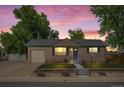 Single-story home at sunset with brick facade, attached garage, and manicured front yard at 2069 E 116Th Ave, Northglenn, CO 80233