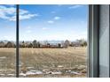 Scenic view of open fields and distant mountains from a window at 2060 Chambers Rd, Brighton, CO 80601