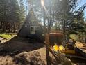 A-frame home nestled in the trees with a deck and stairs, plus off-road vehicle at 274 Lincoln Dr, Idaho Springs, CO 80452