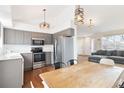 Modern kitchen featuring stainless steel appliances, wood floors, and gray cabinets at 5402 Sweet Grass Ct, Castle Rock, CO 80109