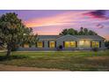 Single-story home featuring a well-maintained lawn and classic vinyl siding under a colorful sunset at 8260 County Road 39, Fort Lupton, CO 80621