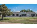Single-story home featuring a well-maintained lawn and classic vinyl siding at 8260 County Road 39, Fort Lupton, CO 80621