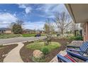 Inviting front yard view featuring a bench, lush landscaping, and a charming home facade with street view at 3600 Olive St, Denver, CO 80207