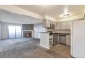 Kitchen with stainless steel appliances and a fireplace in the adjacent living room at 11913 E Harvard Ave # 106, Aurora, CO 80014