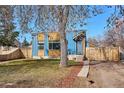 Charming home features a well-kept front lawn, mature trees, and natural light through the windows at 1937 Jay St, Lakewood, CO 80214