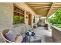 Inviting front porch with cozy seating and brick pillars, perfect for relaxing outdoors at 3525 N Alcott St, Denver, CO 80211