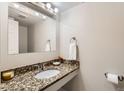 Bathroom with granite countertops, a modern faucet and towel holder, and a well-lit mirror at 5491 E Warren Ave # 224, Denver, CO 80222