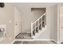 Stairway with carpeted steps, white banister, and entry door to the home at 5491 E Warren Ave # 224, Denver, CO 80222
