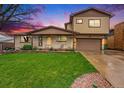 Inviting home featuring a well-maintained lawn, classic brickwork, and a cozy covered porch at 8871 Rutgers St, Westminster, CO 80031