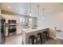 Modern kitchen featuring stainless steel appliances, breakfast bar, pendant lighting, and light wood cabinets at 3378 W 17Th Ave, Denver, CO 80204