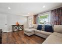 Inviting living room with hardwood floors, sectional sofa, large window, and decorative curtains at 3145 W Farmdale Rd, Englewood, CO 80110