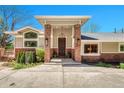 Inviting front entrance with brick pillars, stylish lighting, and a solid wood door with sidelight windows at 5255 Ridge Trl, Littleton, CO 80123