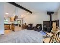 Bright living room with vaulted ceilings, a brick fireplace, and an open floor plan to the kitchen and dining area at 10602 W Patterson Pl, Littleton, CO 80127