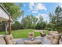 Inviting backyard patio with comfortable seating, a fire pit, and a view of the lush, landscaped yard at 560 Front Range Rd, Littleton, CO 80120