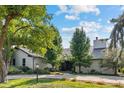 Charming home with a well-manicured lawn, mature trees, and inviting entrance with beautiful landscaping at 560 Front Range Rd, Littleton, CO 80120