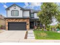 Inviting two-story home featuring an attached garage and neatly landscaped yard at 5021 S Rome St, Aurora, CO 80015