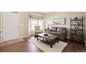 Inviting living room with hardwood floors, neutral paint, and bay window at 5128 Longs Peak St, Brighton, CO 80601
