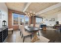 Open floor plan with a modern chandelier over the dining table, exposed brick and ductwork add industrial charm at 1301 Wazee St # 3C, Denver, CO 80204