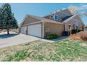 Exterior home showing a two-car garage and lawn at 1225 Baker St, Longmont, CO 80501