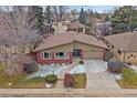 Charming single-story home featuring a brick facade, mature landscaping, and an attached two-car garage at 6630 E Virginia Ave, Denver, CO 80224