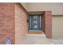 Close-up of the home's entrance, showcasing a blue front door and brick details at 6630 E Virginia Ave, Denver, CO 80224