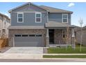 Attractive two-story home with stone veneer, siding, manicured lawn, and a convenient two-car garage at 546 Red Rock Pl, Brighton, CO 80601