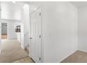 Bright hallway with neutral carpet, fresh white walls, and staircase leading to upper level at 546 Red Rock Pl, Brighton, CO 80601
