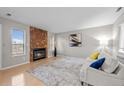 Cozy living room with a stone fireplace, plush seating, and a large window at 9409 W 89Th Cir, Broomfield, CO 80021